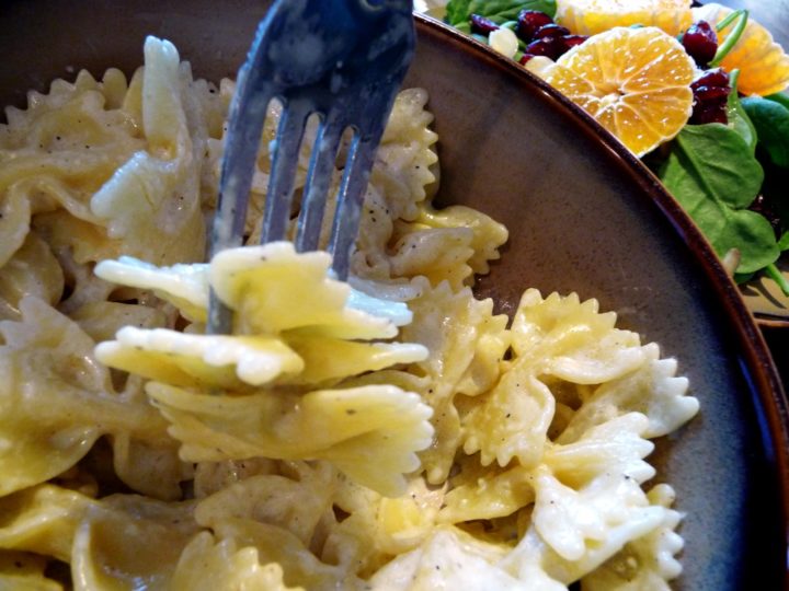 close up of a fork on a plate with pasta and homemade alfredo sauce