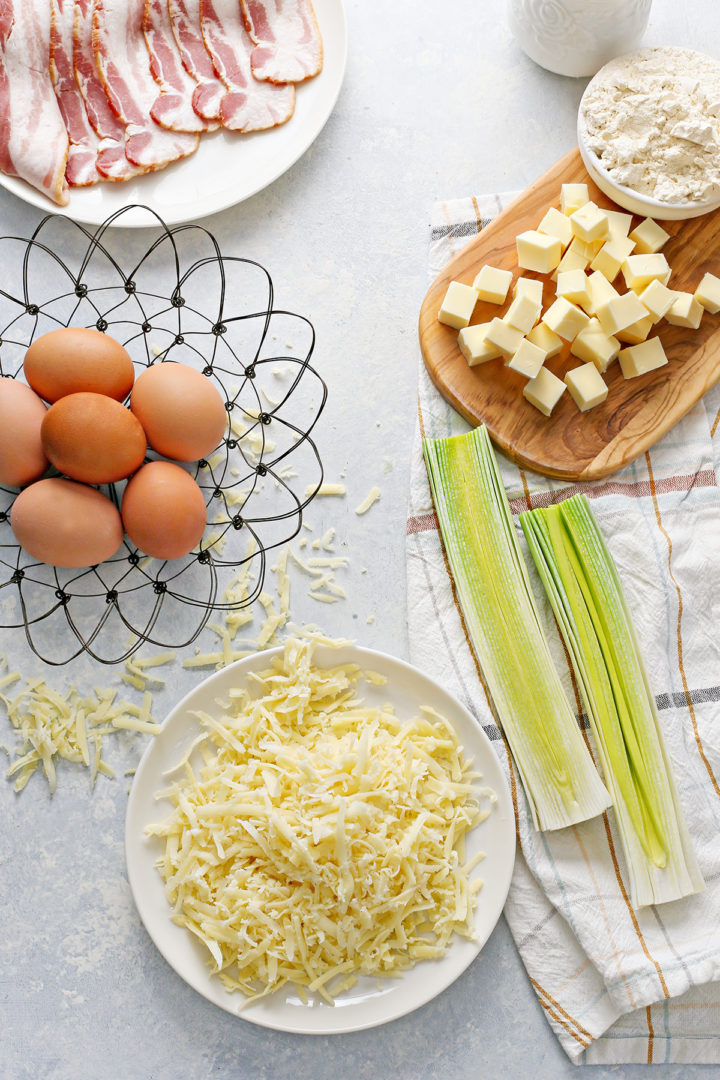 cleaned leeks on a dish towel next to other ingredients for a recipe