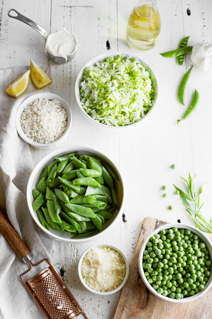 a bowl of washed and cut leeks next to bowls of peas