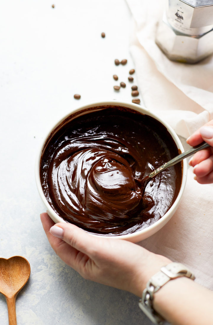 woman stirring a bowl of chocolate ganache