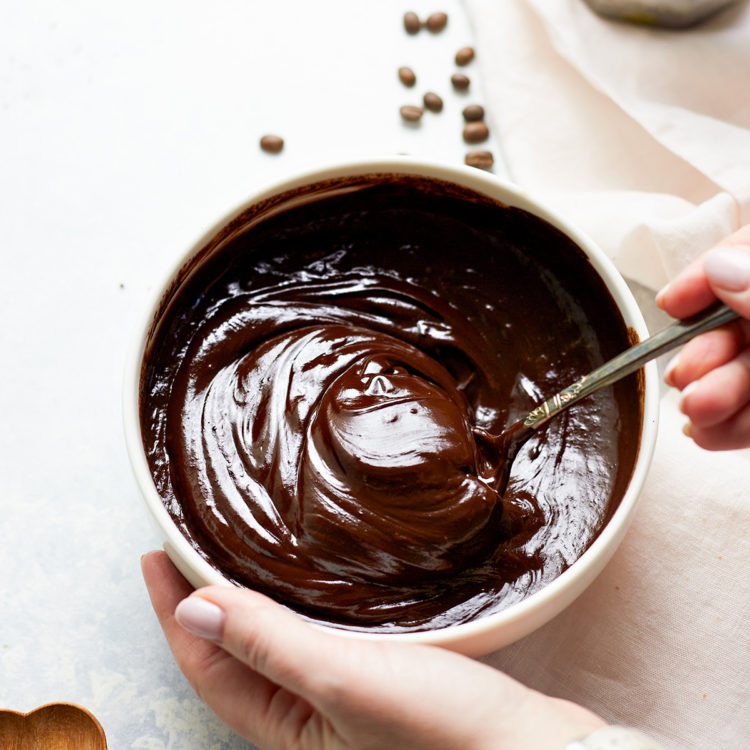 woman stirring a bowl of chocolate ganache