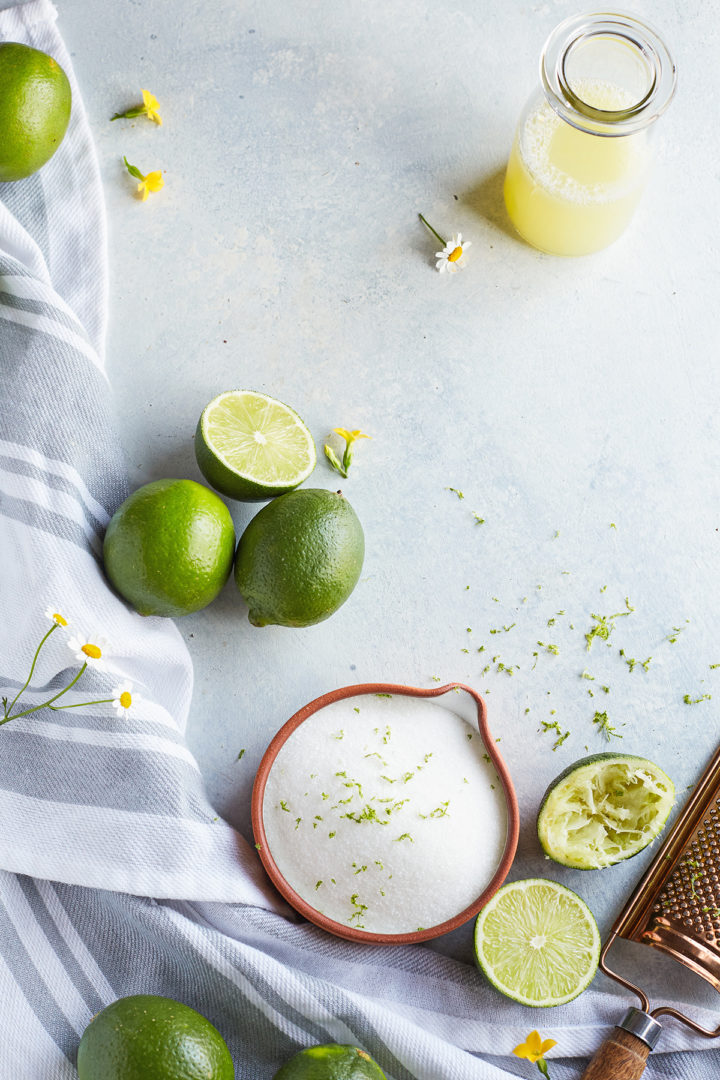 fresh limes, a bottle of fresh squeezed juice from a lime, and freshly squeezed limes