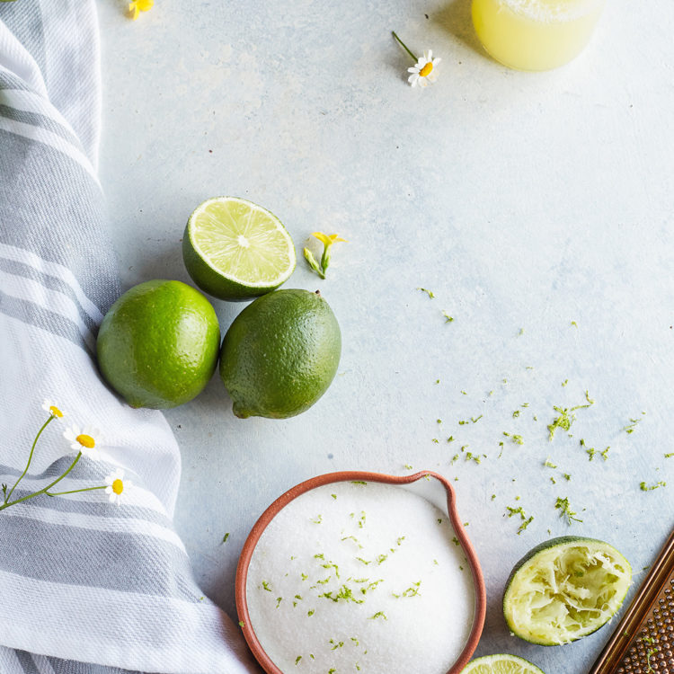 fresh limes, a bottle of fresh squeezed juice from a lime, and freshly squeezed limes