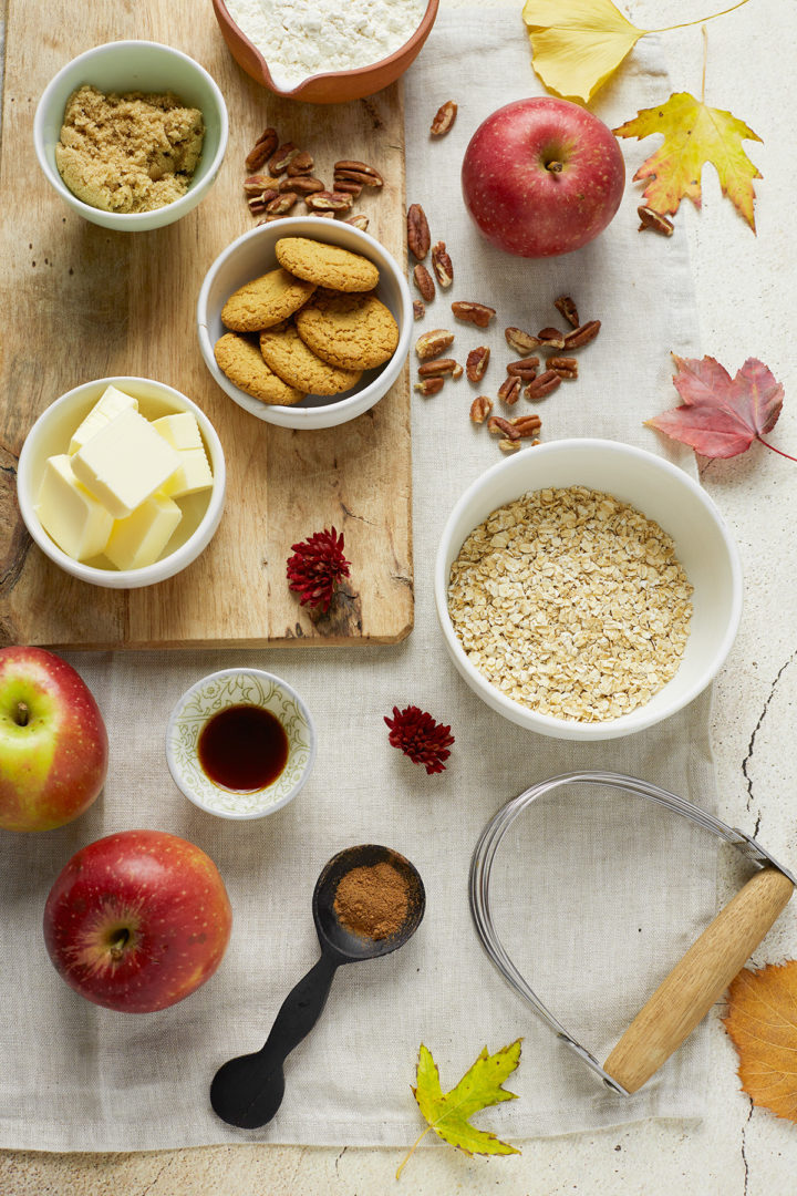 Overhead view of ingredients to make bourbon apple crisp, surrounded by fall table decor. 