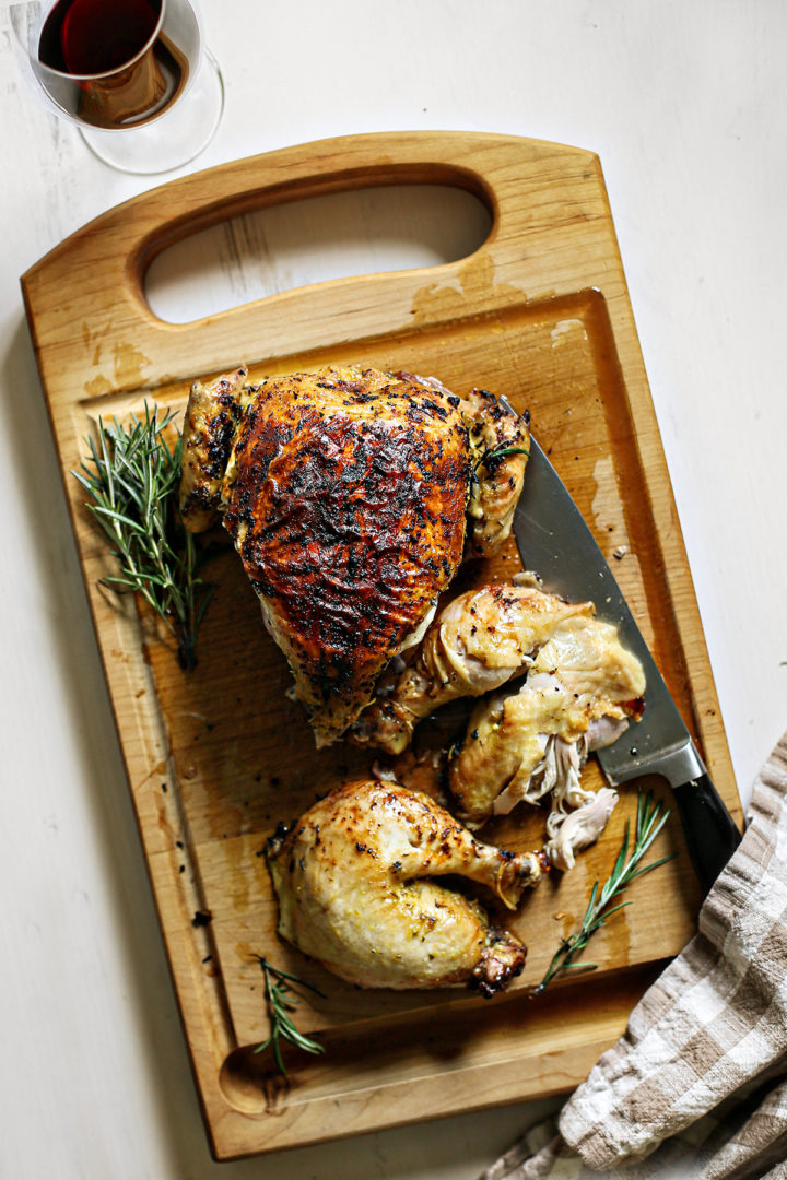 Freshly roasted chicken, sliced on a wooden cutting board, ready to be added to a quinoa salad with chicken for a hearty and flavorful meal.