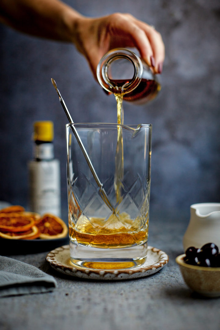 woman making an old fashioned cocktail