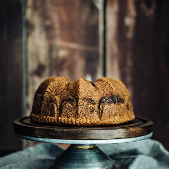 cardamom coffee cake on a wooden cake stand