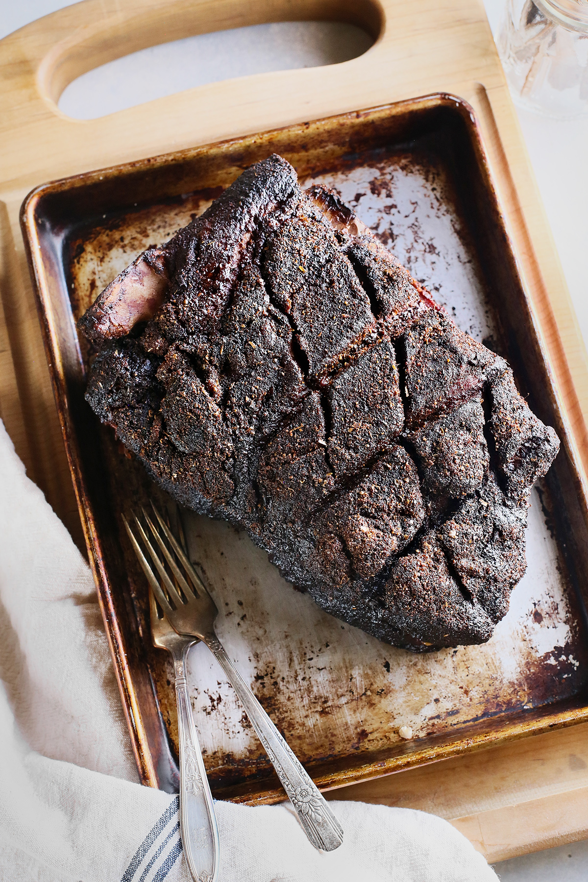 brined smoked pork shoulder with a great bark resting on a baking sheet