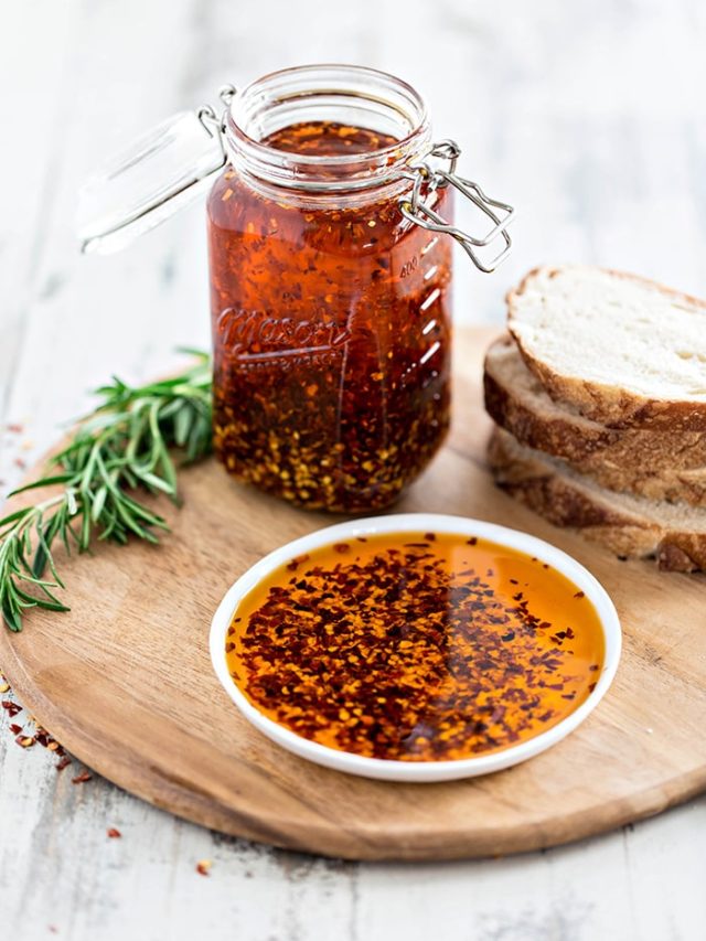 plate with dipping oil and slices of bread on a cutting board