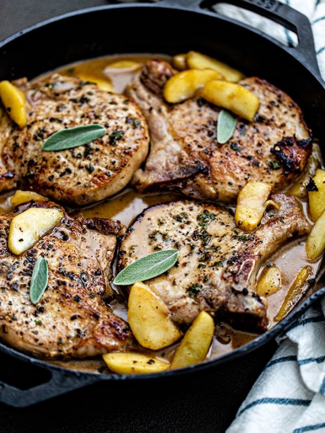 pork chops with sage in and apples in a cast iron skillet