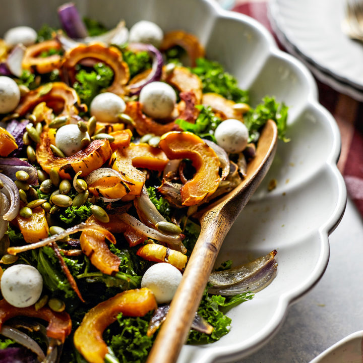 kale salad with roasted delicata squash in a bowl