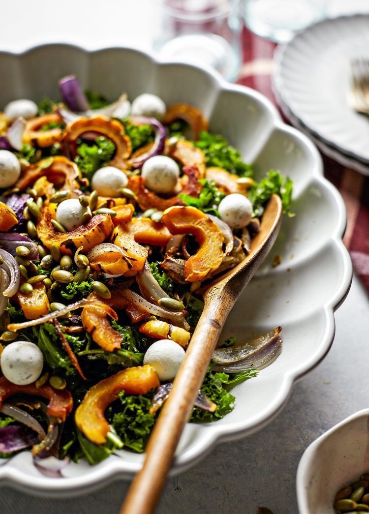 kale salad with roasted delicata squash in a bowl