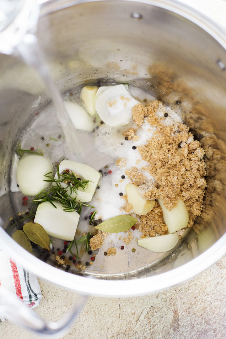 adding hot water to a pot with other ingredients to make a brine for smoked turkey