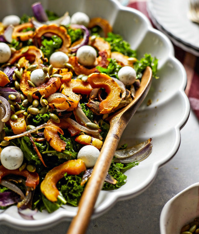 kale salad with roasted delicata squash in a bowl