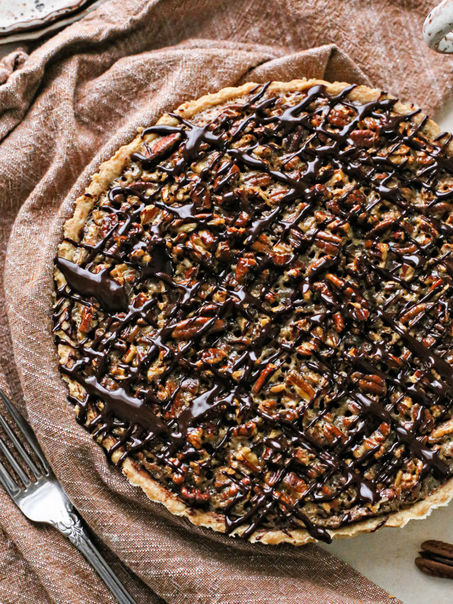 photo of a chocolate pecan tart recipe drizzled in chocolate ganache