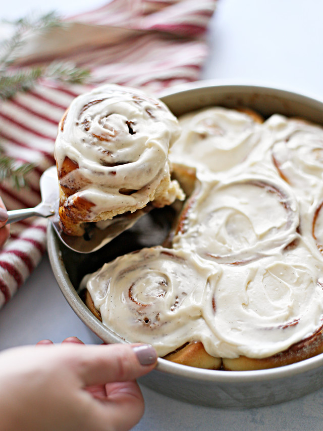 woman serving homemade cinnamon rolls