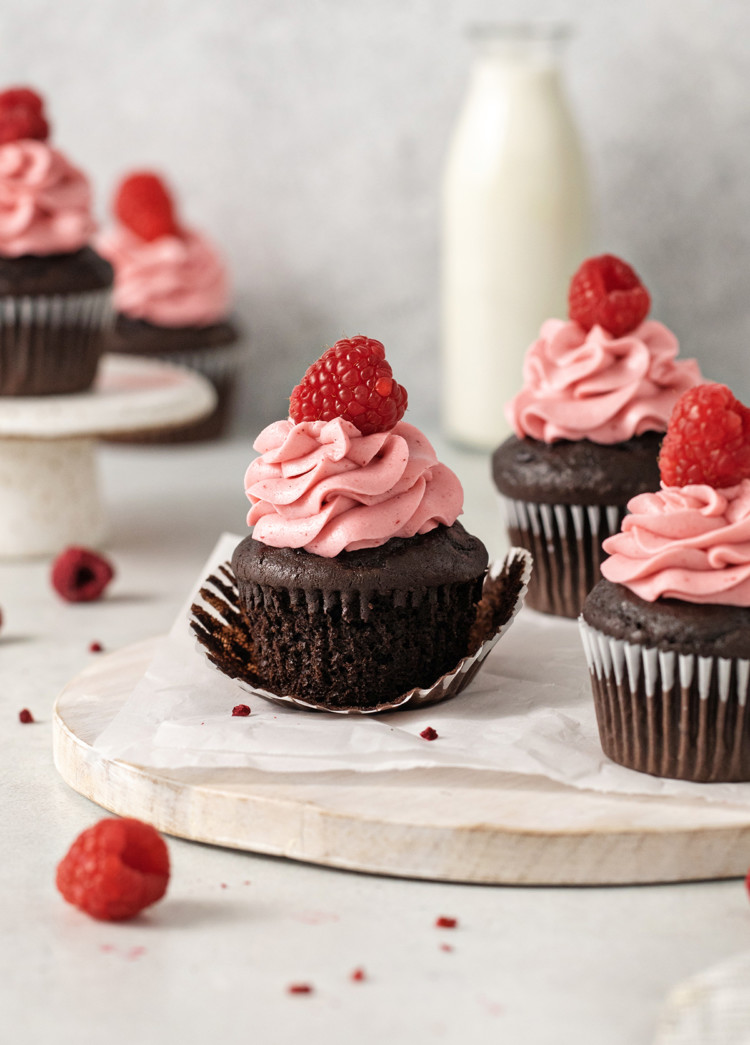 chocolate raspberries cupcakes next to a bottle of milk