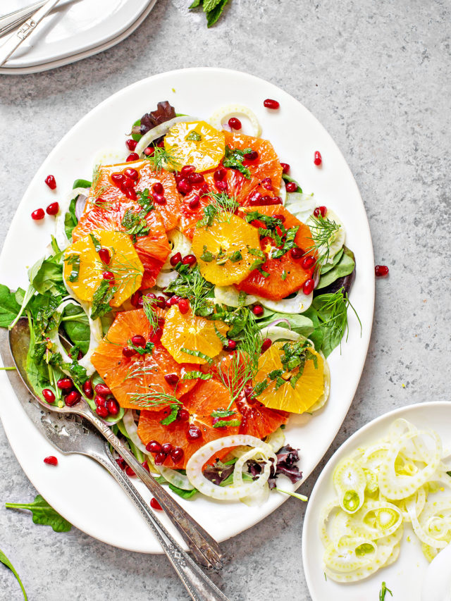 fennel salad on a white platter with oranges and pomegranate