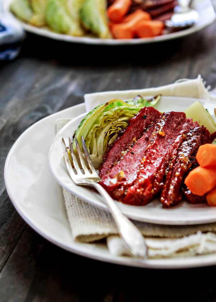 corned beef on a white plate with cabbage and carrots