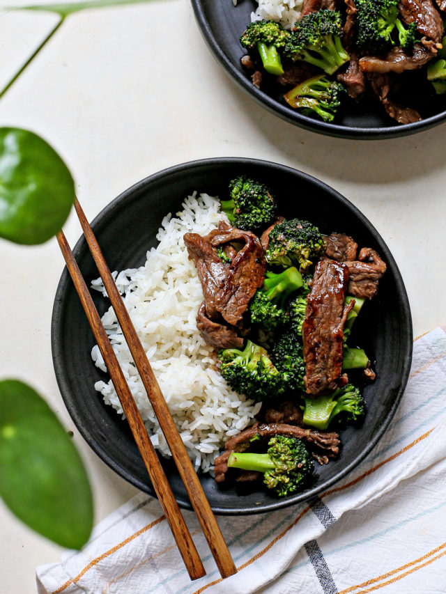 overhead photo of Chinese beef and broccoli being served on two black plates