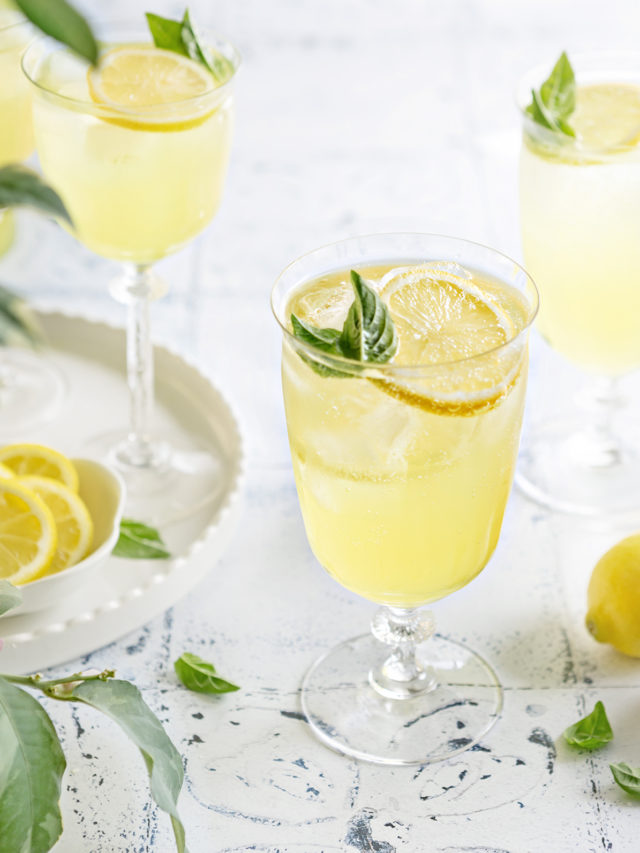 photo of 3 glasses of limoncello spritz on a white and blue tile background