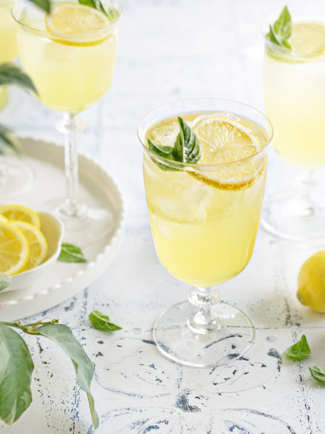 photo of 3 glasses of limoncello spritz on a white and blue tile background