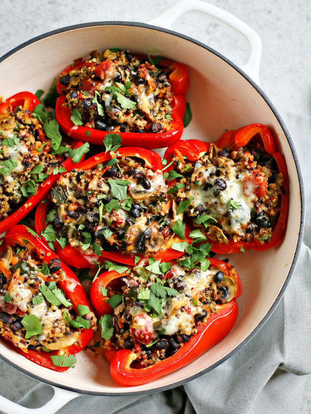 quinoa stuffed peppers in a white baking dish on a grey background