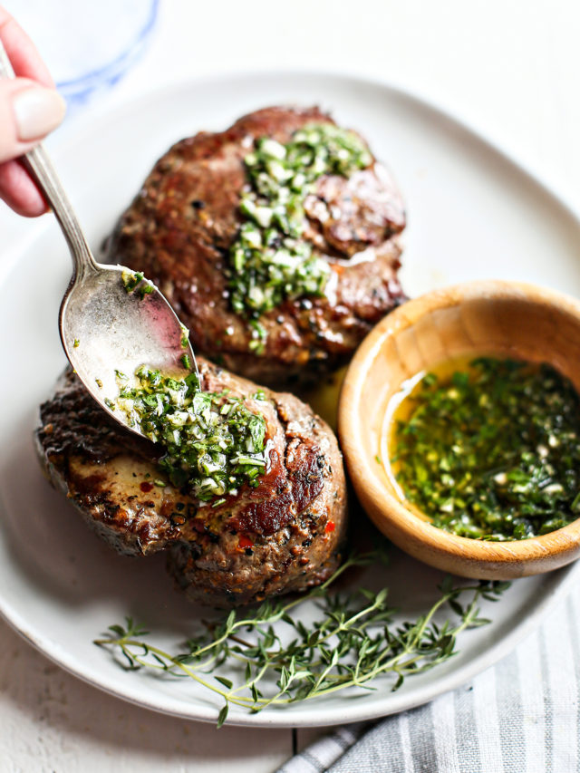 woman spooning gremolata sauce onto seared steaks