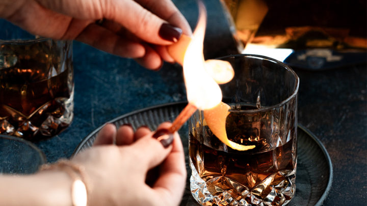 Premium Photo  Pouring whisky from a jigger into a rocks glass with a big  ice cube