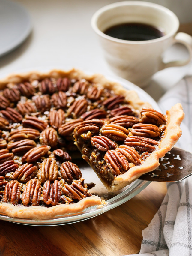 slice of bourbon pecan pie being served from a pie plate