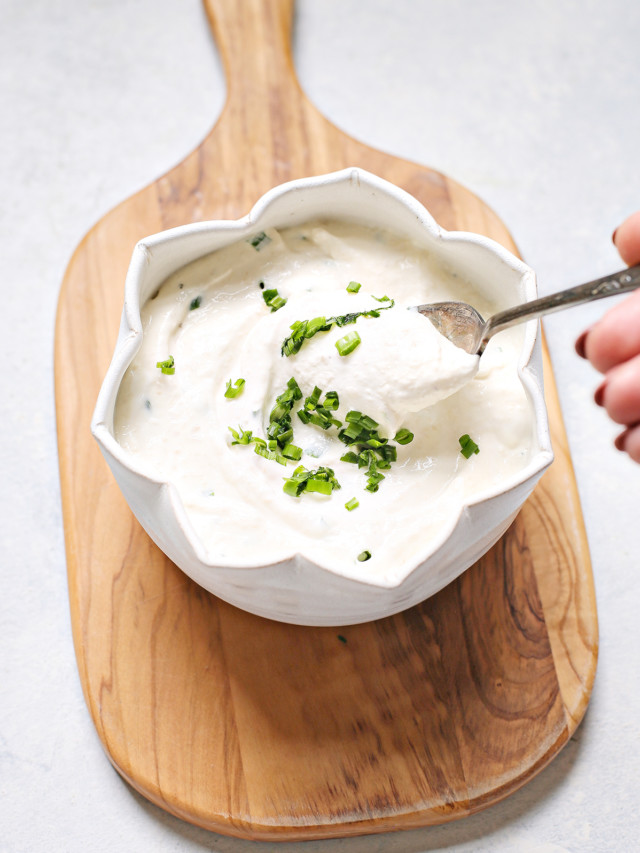 woman stirring a bowl of homemade horseradish sauce for prime rib