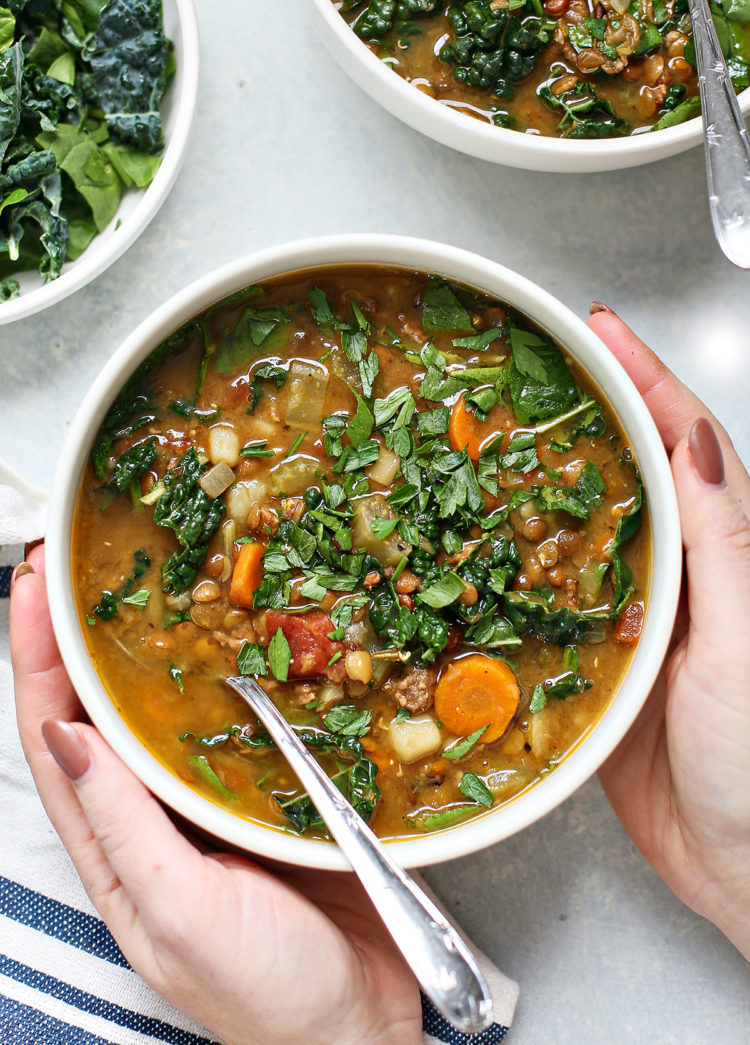 woman holding a bowl of instant pot lentil soup