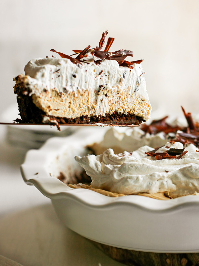 peanut butter pie with chocolate graham cracker crust in a white pie plate being served with a pie server