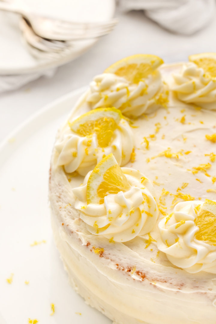 lemon cake with lemon cream cheese frosting on a white plate