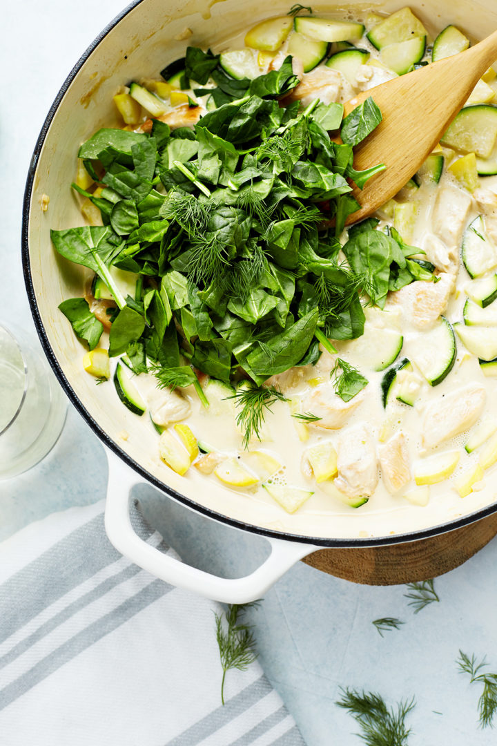 adding the vegetables and chicken to the pasta primavera sauce