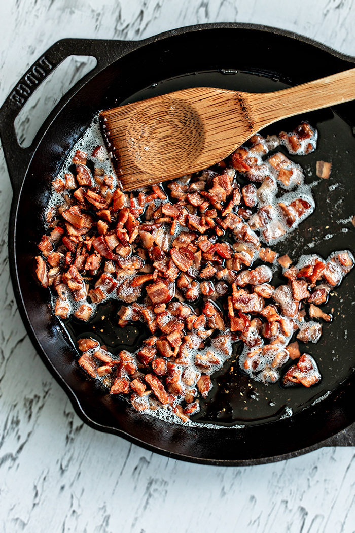 bacon crumbles cooking in a cast iron pan