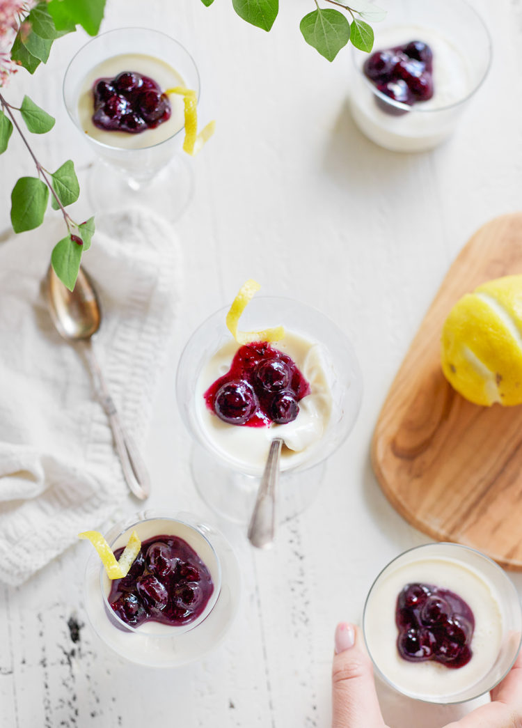 dessert glasses filled with lemon panna cotta and topped with blueberries