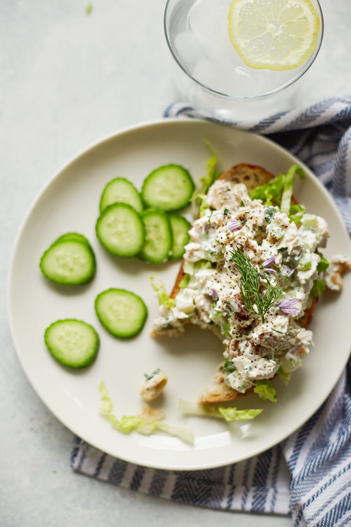 a partially eaten slice of bread with green apple chicken salad