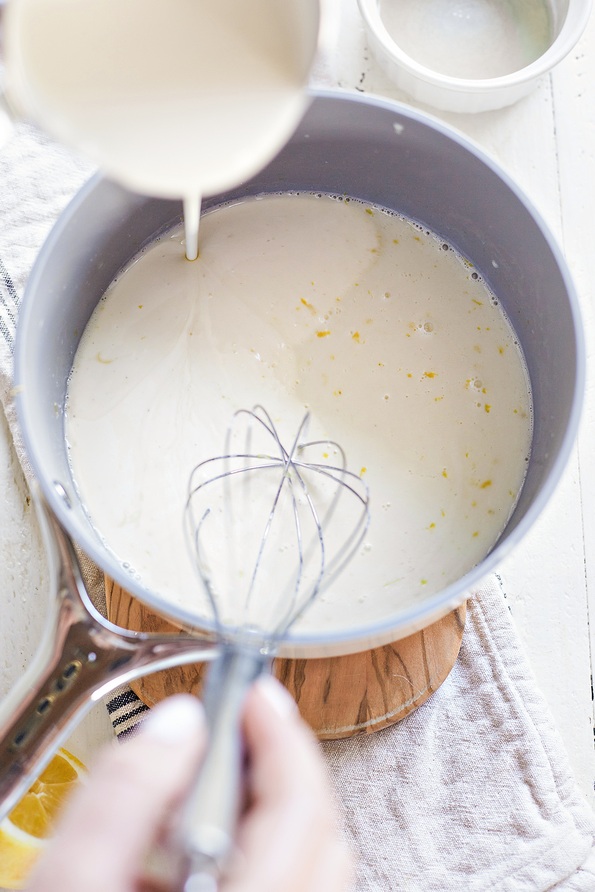 woman making lemon panna cotta in a saucepan