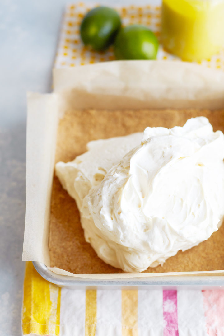 cheesecake filling added to a square pan with a graham cracker crust