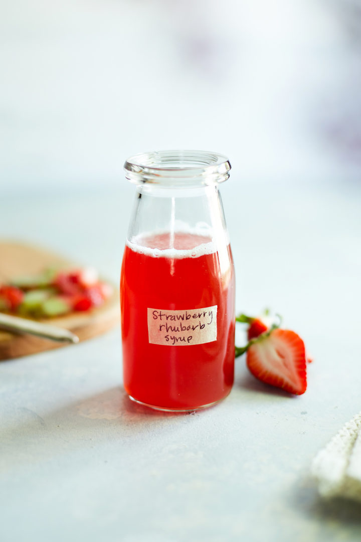 strawberry rhubarb simple syrup in a glass jar  