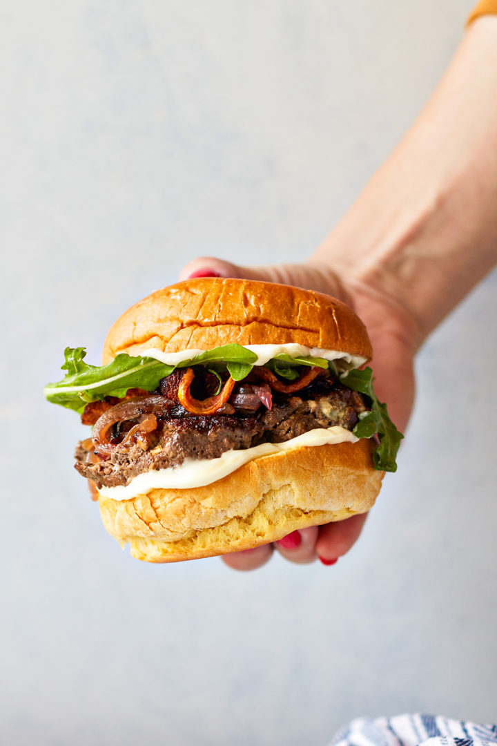 woman eating a bacon and blue cheese burger