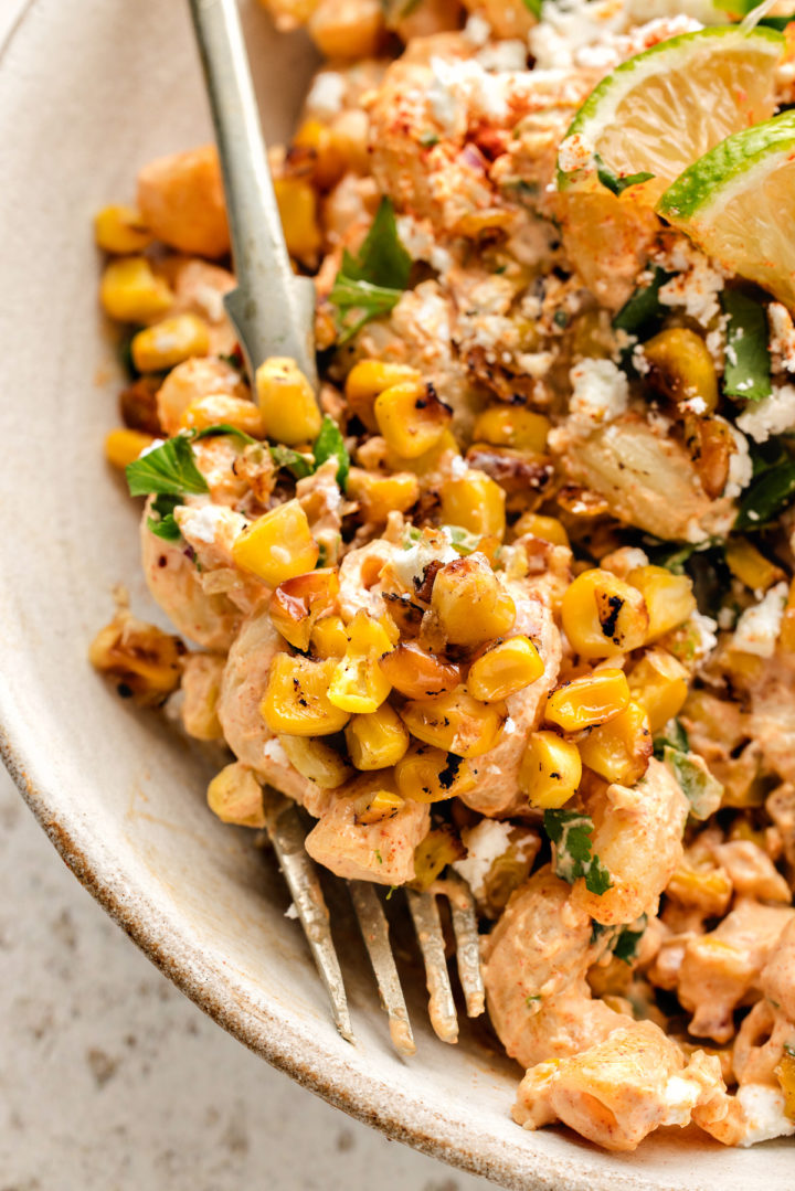 fork in a bowl of elote pasta salad