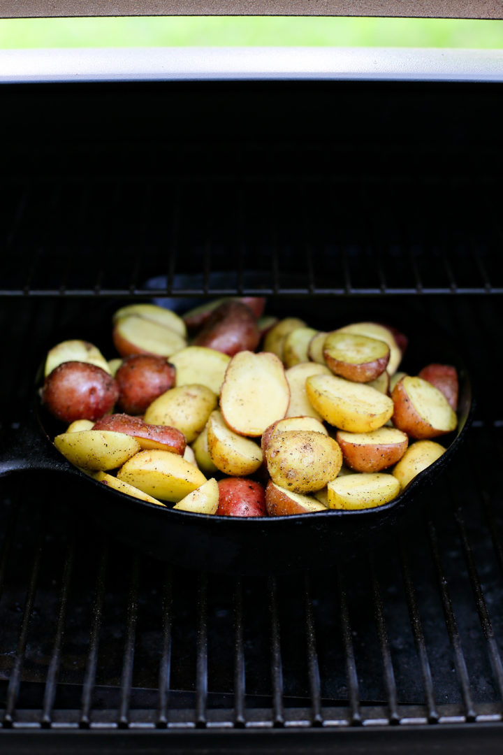 a cast iron pan of roasted potatoes on the traeger