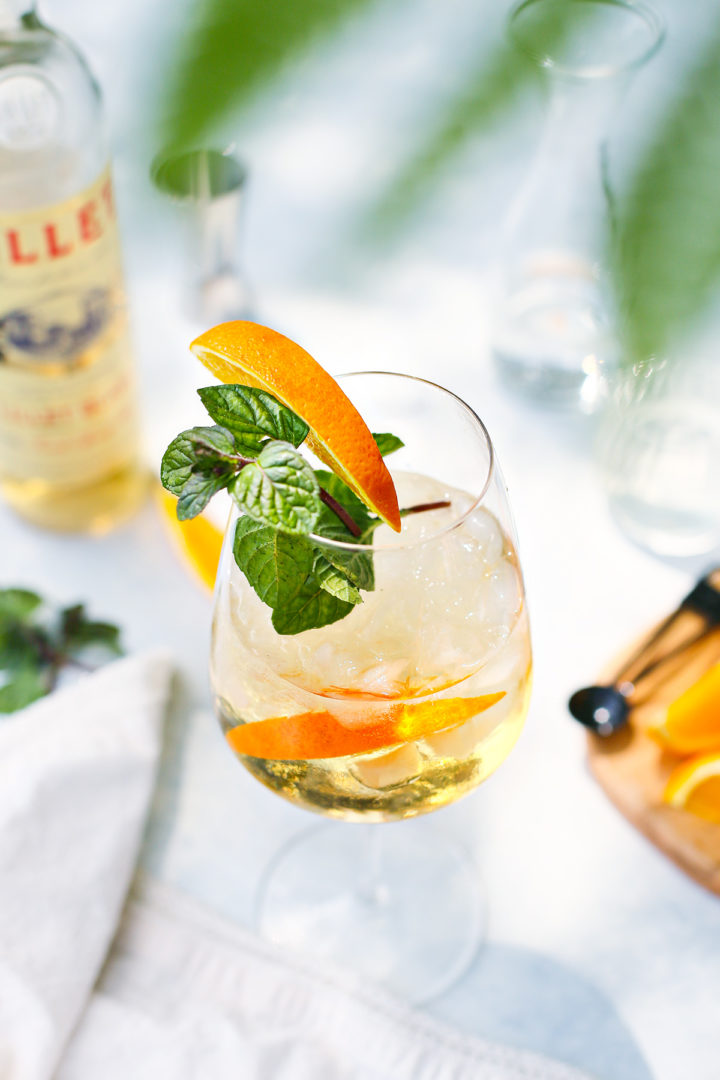 lillet spritz cocktail in a glass garnished with orange slice and fresh mint