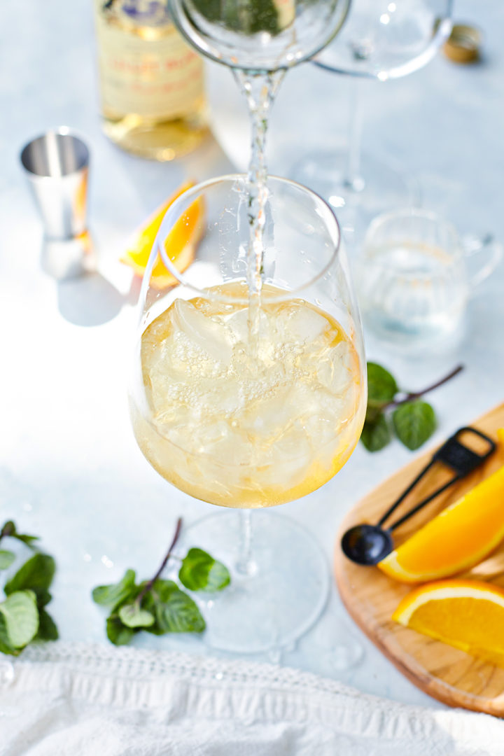 adding club soda to a glass of lillet blanc