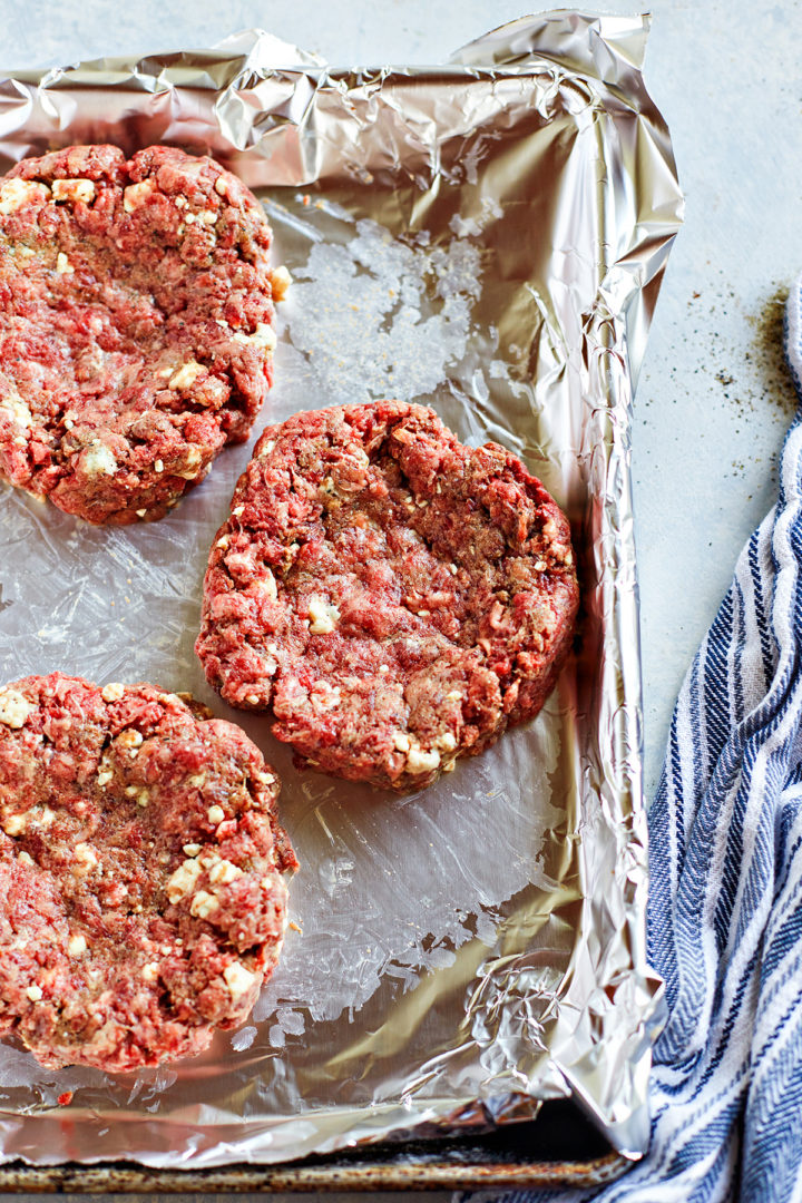 blue cheese stuffed burger patties on a baking cheese