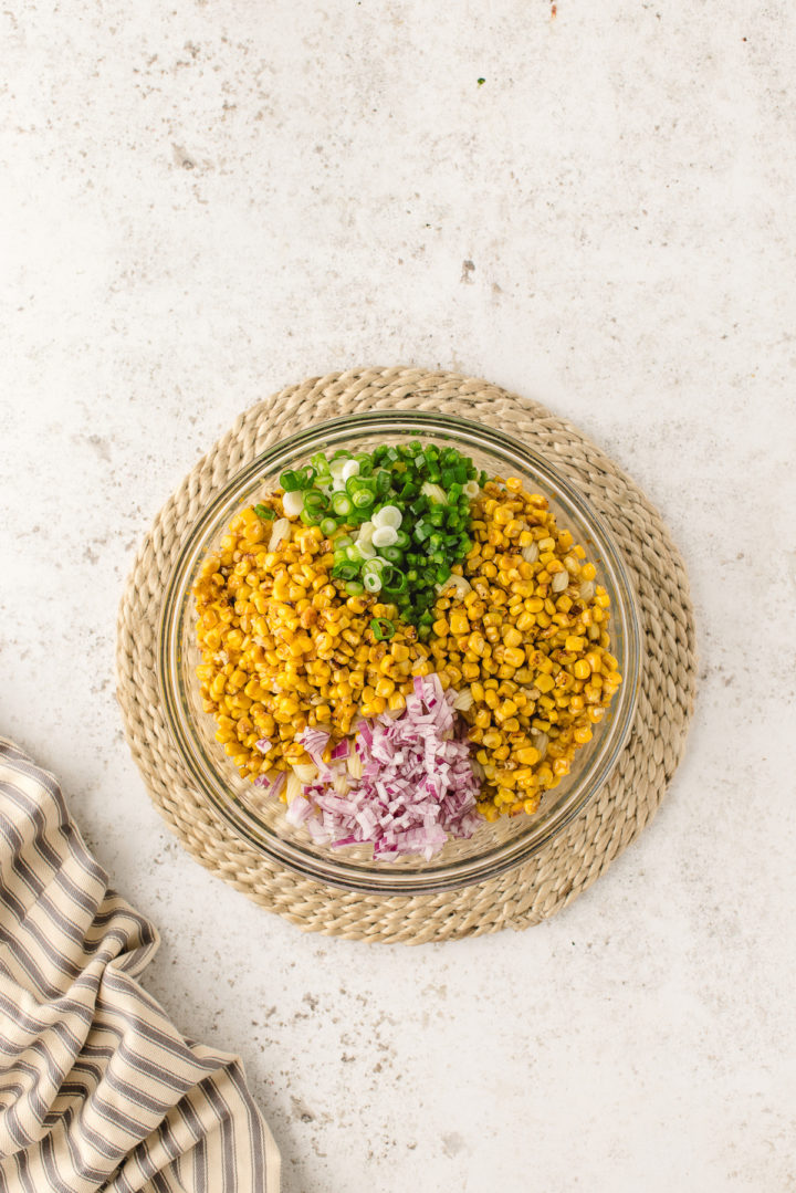 combining corn pasta salad ingredients in a bowl