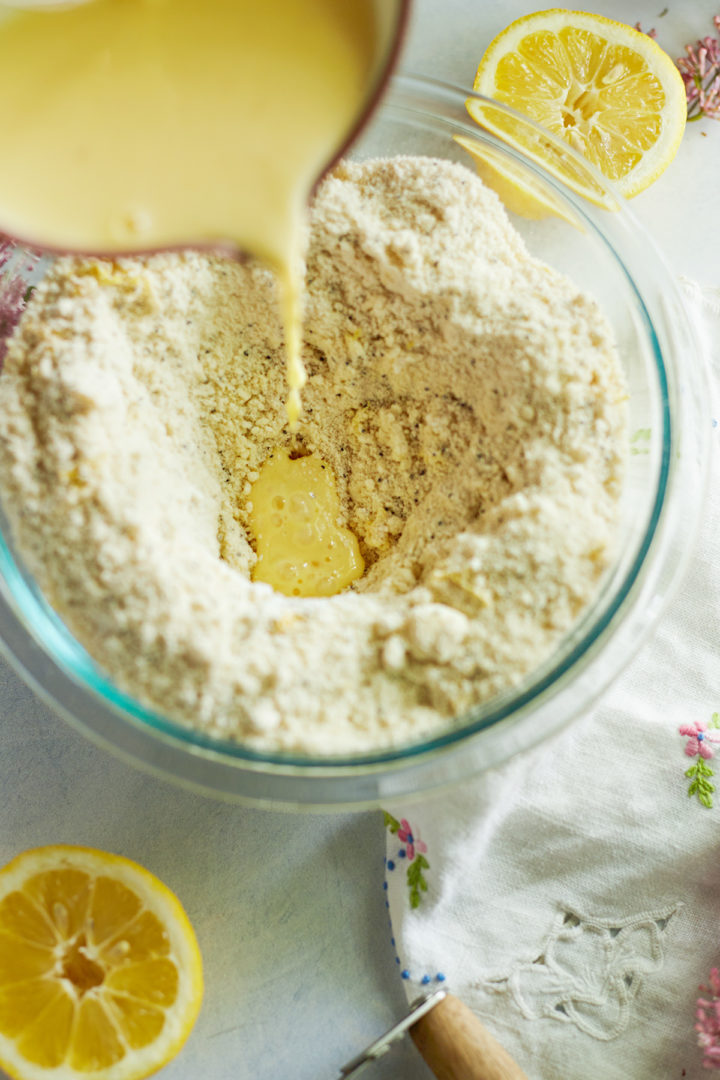 woman pouring buttermilk mixture into scone dry ingredients