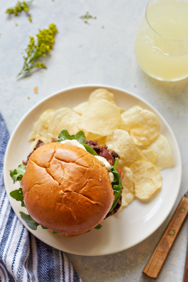 blue cheese burger on a plate with potato chips